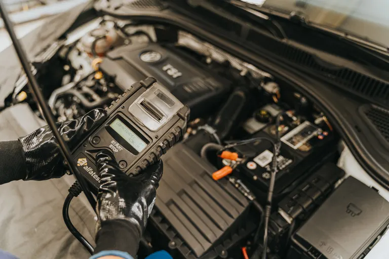 Mechanik diagnozujący samochód testerem diagnostycznym
